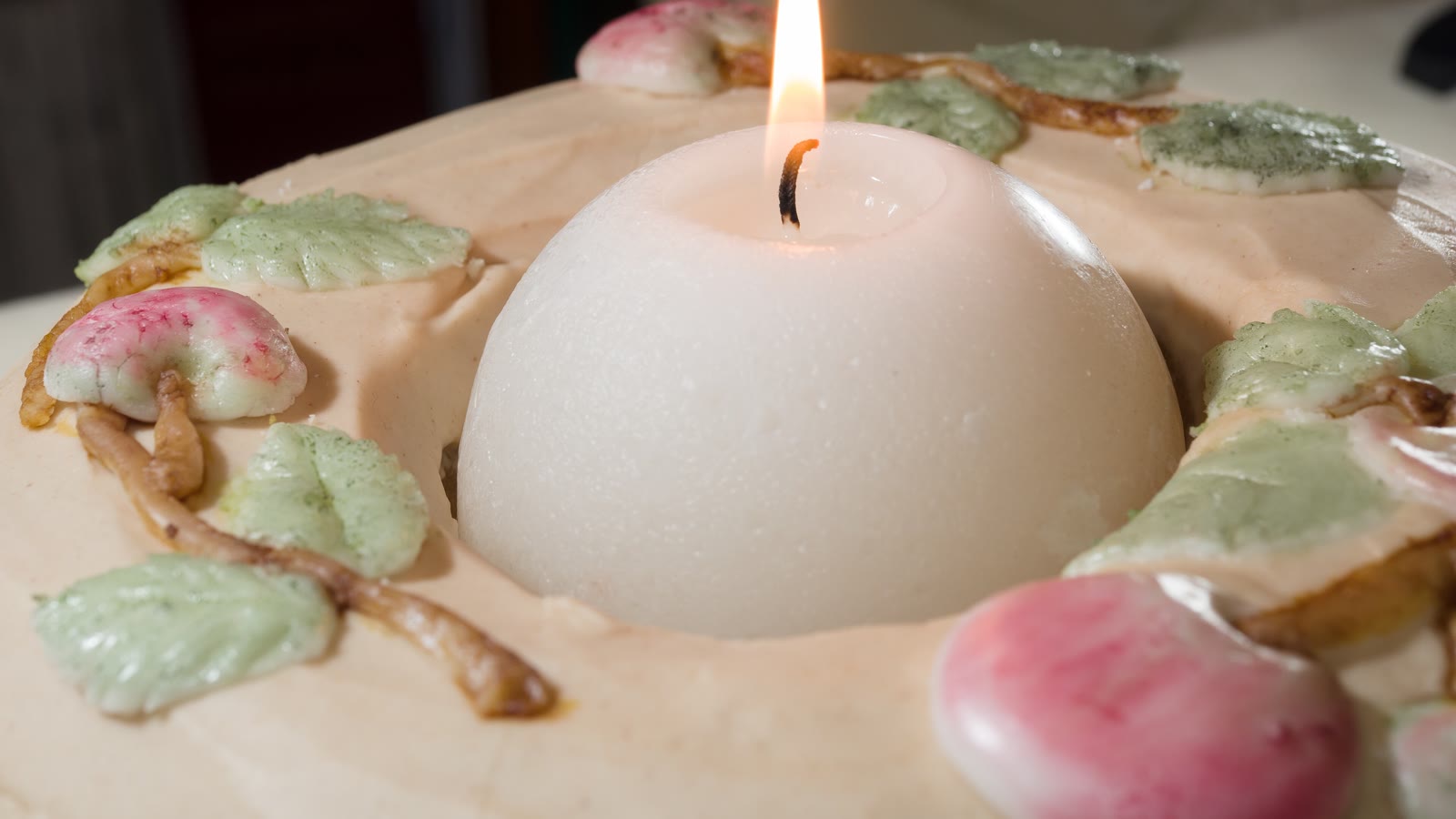 A decorated birthday cake with a single lit candle